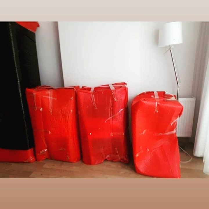 Kırmızı koruyucu örtü ve bantla paketlenmiş sandalyeler taşınma öncesi